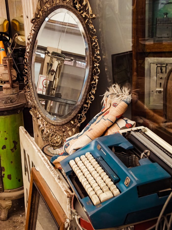 get-in-touch A vintage blue typewriter and ornate mirror in an antique store, evoking nostalgia.
