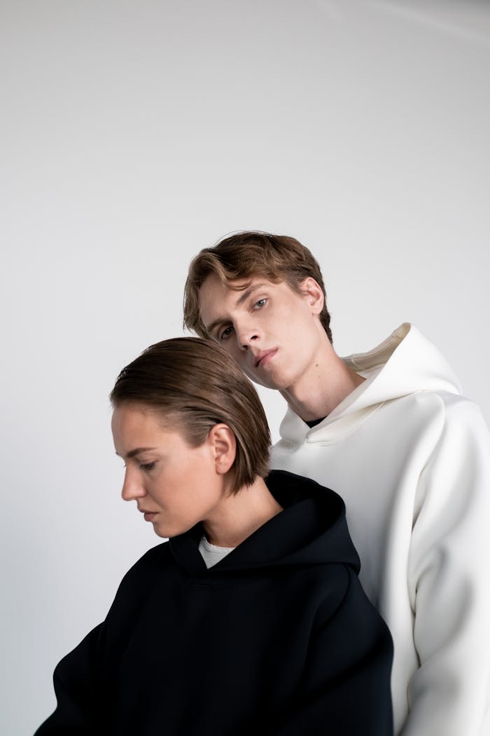 Mastering the First Impression: Your intriguing post title goes here Stylish portrait of a couple in modern hoodies against a neutral background.